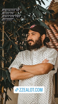 a man with a beard standing in front of a tree